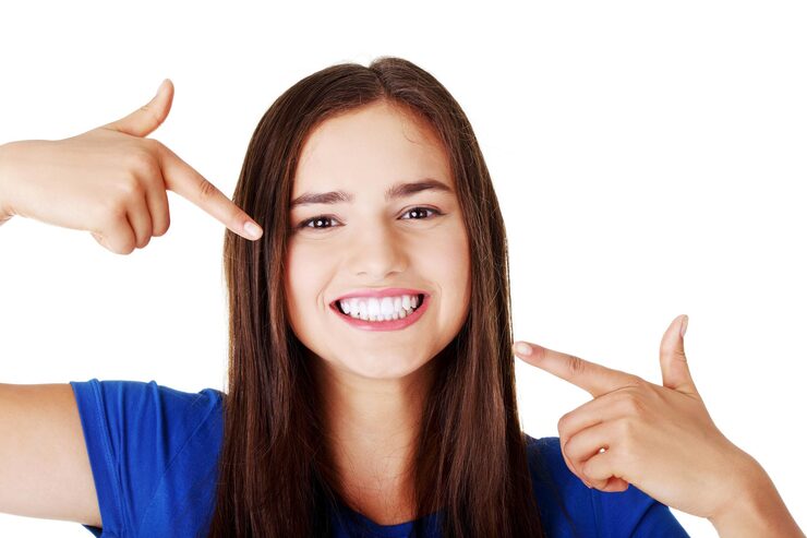 Portrait of smiling young woman gesturing against white background
